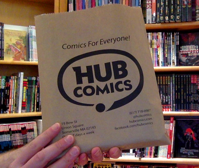 Photo of hands holding a Hub Comics merch bag